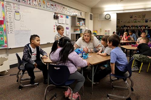 teacher and student sitting at a table talking.